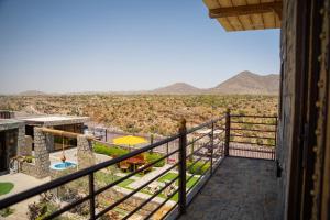 a balcony of a house with a view of the desert at nbz chalet Jasmine stairs in Al ‘Aqar