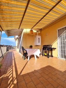 een overdekte patio met een tafel en een piano bij Attico con terrazzo Relax in Ladispoli