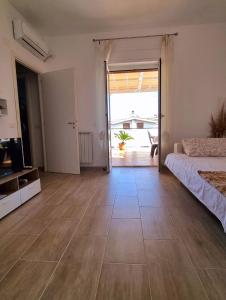 een grote kamer met een bed en een glazen schuifdeur bij Attico con terrazzo Relax in Ladispoli