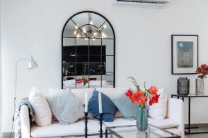 een woonkamer met een witte bank en een glazen tafel bij GuestReady - Anakaj House in Funchal