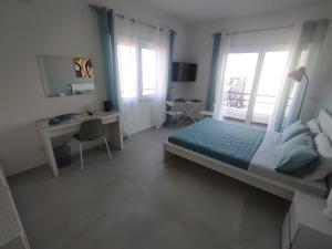 a bedroom with a bed and a desk and windows at B&B La Finestra sul Mare in Milazzo