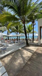 a beach with tables and chairs and palm trees at Villa Aisawan in Phuket