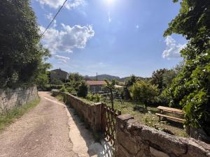 een onverharde weg naast een hek en een bank bij Maison En Pierre Dans Village Calme in Monacia-dʼAullène