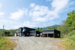 een zwart huis met een oprit bij Landmark Annex in Furano