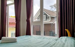 大叻的住宿－Ngô Gia Home，一间卧室设有一张床和一个大窗户