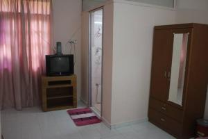 baño con ducha y tocador con TV. en Wafi Guesthouse, en Kuala Terengganu