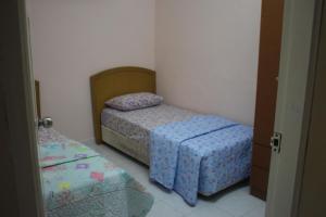 1 dormitorio con 2 camas y puerta abierta en Wafi Guesthouse, en Kuala Terengganu