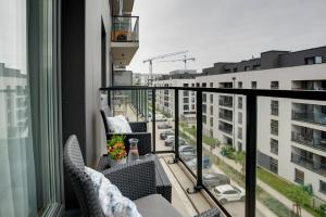 a balcony with chairs and a view of a city at Apartament Premium, 15min od Rynku, parking w cenie in Wrocław