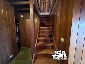 una escalera en una casa con paredes y suelos de madera en Cedar Haven, en Jindabyne