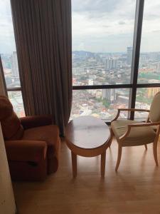 a living room with a couch and a table and a large window at Presidential Service Suite At Times Square in Kuala Lumpur
