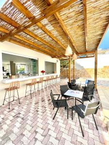 a patio with chairs and tables and a bar at Mediterranea Apartments in Kato Daratso
