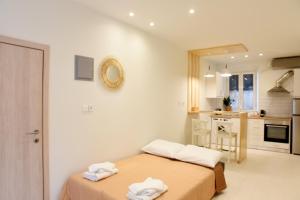 una stanza bianca con due letti e una cucina di Donatello a Città di Corfù