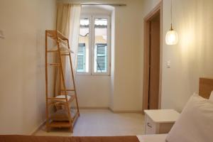 una camera da letto con una scala accanto a una finestra di Donatello a Città di Corfù