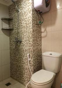 Un pequeño baño con inodoro y ducha. en Cozy Room @ Hallo Tidur by Tio, en Bandung 38 fotos más