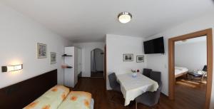 Habitación con mesa, cama y dormitorio. en Pension Steinadler, en Neustift im Stubaital