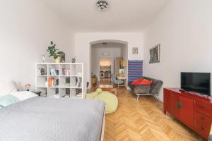 Bright & Spacious Loft With Basilica View في بودابست: غرفة نوم مع سرير وغرفة معيشة