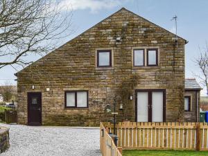 a brick house with a wooden fence in front of it at Wesley Old Hall House in Bacup