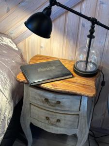 a lamp and a book on a table next to a bed at Koivula Guest House in Kotka