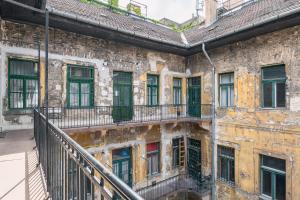 um antigo edifício de tijolos com janelas e uma escadaria em Bright & Spacious Loft With Basilica View em Budapeste