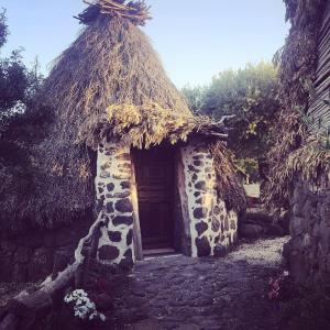 un pequeño edificio con techo de césped y puerta en Ovile Juanne Loddo en Orosei