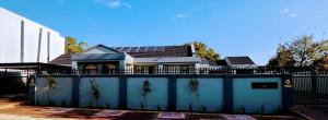una casa con pannelli solari in cima a una recinzione di 136 on 4th a Johannesburg