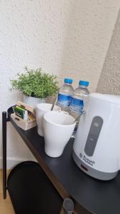 einer Theke mit einem Mixer, Schalen und Wasserflaschen in der Unterkunft Barcelona PR Guesthouse in El Prat de Llobregat