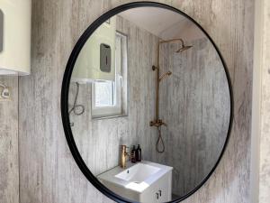 a bathroom mirror with a sink and a shower at ALANTOS ŽIRGAI Holiday Villas sauna or hottube additional price in Alanta