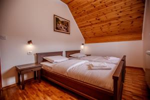 una camera da letto con un letto grande con soffitto in legno di Montagna Resort a Žabljak