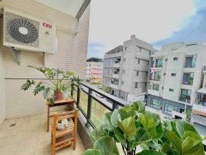 an apartment balcony with plants and a fan at Xinzhan 23 B&B in Taitung City