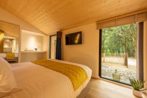 a bedroom with a large bed and a large window at Cantu di Fiumu in Zonza