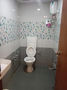 a bathroom with a toilet and a sink at Hotel Shreeji's in Gandhinagar