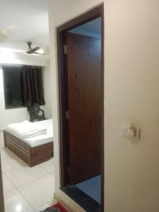 a door to a room with a bed and a mirror at Hotel Shreeji's in Gandhinagar