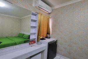 a small room with a green bed on a counter at B Nature Aeropolis Inn in Teko
