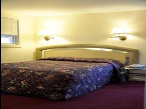 Countryside Motel في فيشكيل: سرير في غرفة نوم مع مصباحين على الحائط