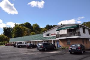 un bâtiment avec des voitures garées dans un parking dans l'établissement Countryside Motel, à Fishkill