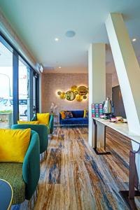 uma sala de estar com mobiliário amarelo e azul e pisos de madeira em The Sebel Wellington Lower Hutt em Lower Hutt
