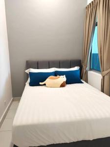 a bed with two blue pillows and a stuffed animal on it at W45WarmStay@GoldenHillsNightMarket in Brinchang