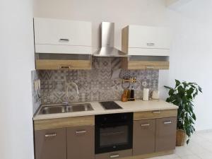 a kitchen with a sink and a stove at Apartment Bella Costa II. in Kaštela