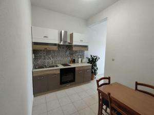 a kitchen with brown cabinets and a table and a dining room at Apartment Bella Costa II. in Kaštela +25 photos