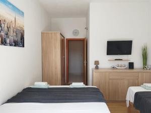 a bedroom with two beds and a flat screen tv at Apartment Bella Costa II. in Kaštela