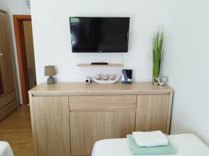 a television on top of a wooden cabinet in a room at Apartment Bella Costa II. in Kaštela