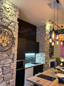 cocina con pared de piedra y mesa en Grenoble LA SUITE 2 spa jaccuzzi et sauna privatif en Grenoble