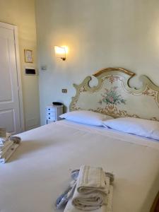 a bedroom with a white bed with a large headboard at Sourire Hotel in Rome