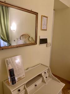espejo sobre un tocador en el baño en Sourire Hotel, en Roma