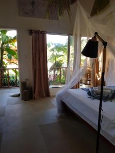 a bedroom with a bed and a large window at Tropical Bungalows-Siargao in General Luna