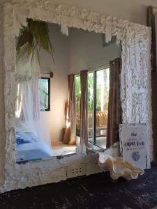 a large mirror in a room with a window at Tropical Bungalows-Siargao in General Luna