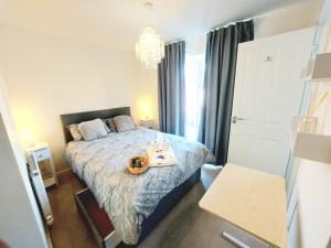 a small bedroom with a bed and a chandelier at 3-BED HOUSE, FULL KITCHEN, ENSUITE, SMART TV in all rooms, KETLEY, TELFORD in Telford