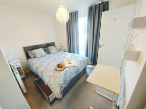 a small bedroom with a bed and a chandelier at 3-BED HOUSE, FULL KITCHEN, ENSUITE, SMART TV in all rooms, KETLEY, TELFORD in Telford