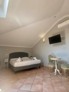 1 dormitorio con 1 cama y TV en la pared en Sourire Hotel, en Roma