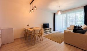 a living room with a table and a couch at White&Blue Apartman in Siófok